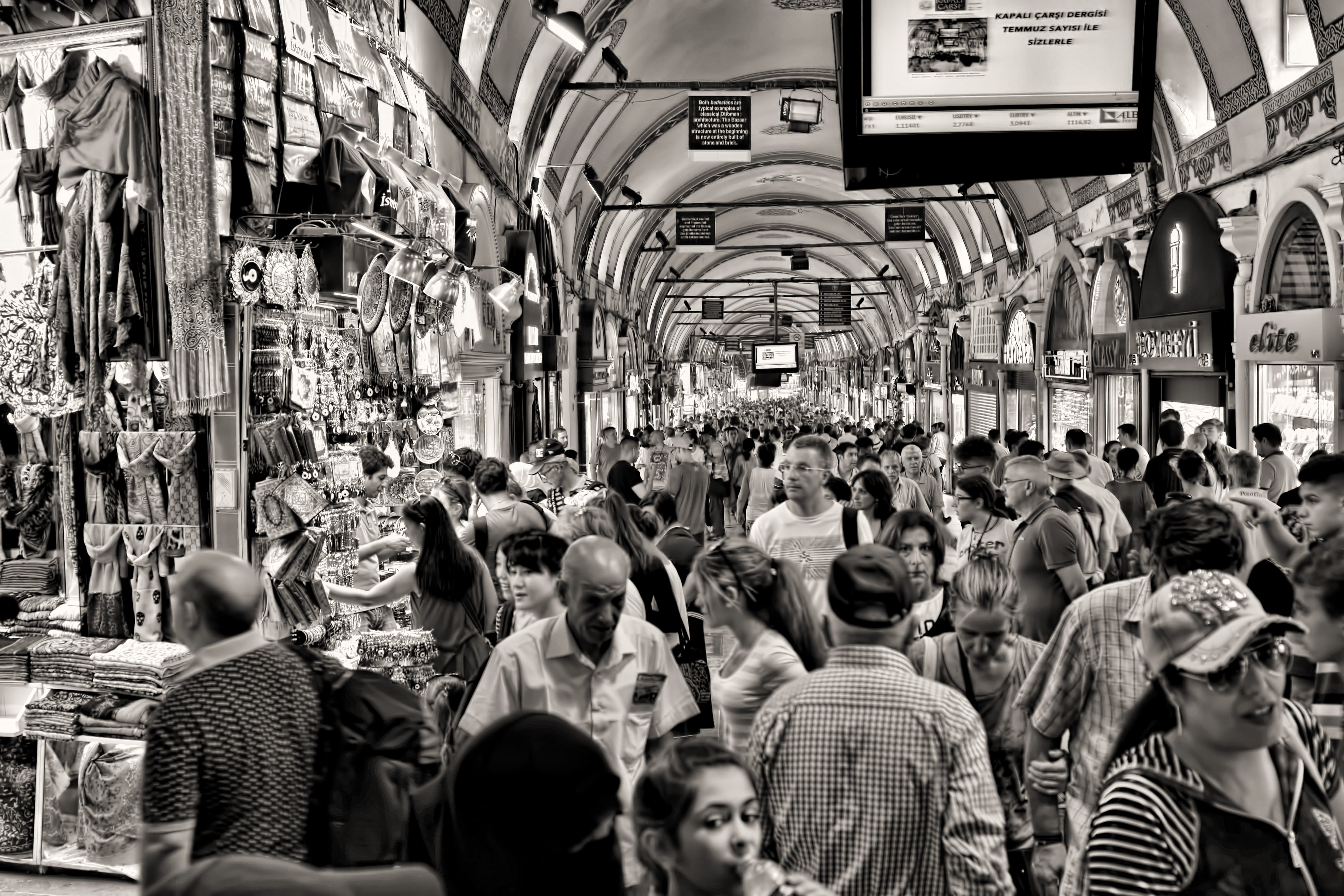 Black and white phote of people in indoor market. In Behavioral Science, people's behavior can be measured, described, predicted, and influenced.